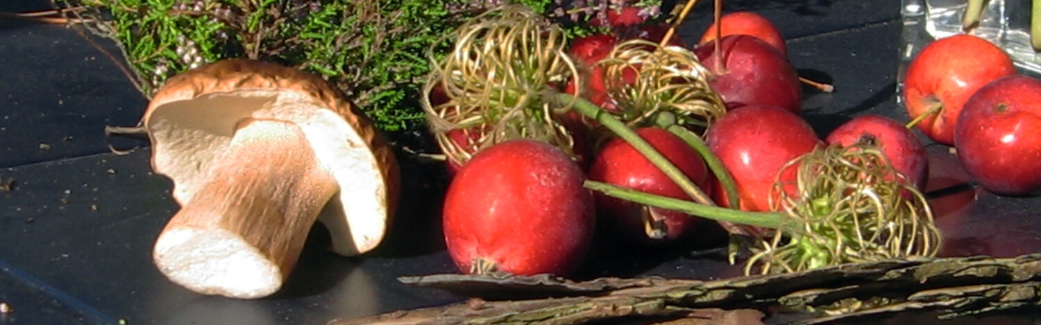 Decoración otoñal típica sobre una mesa: manzanas, una seta, brezo
