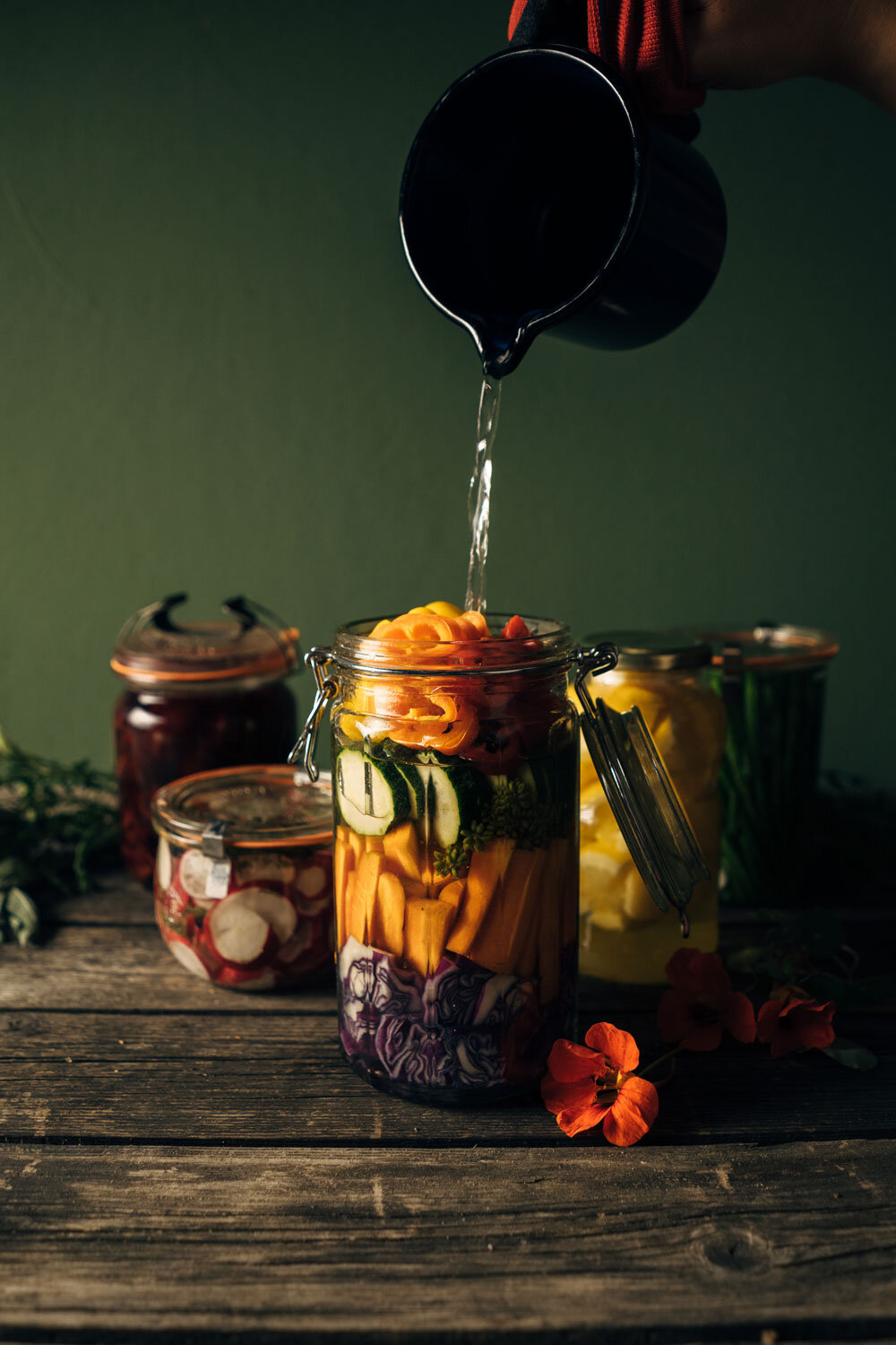 Conservar verduras: se vierte líquido en un tarro con verduras de colores troceadas