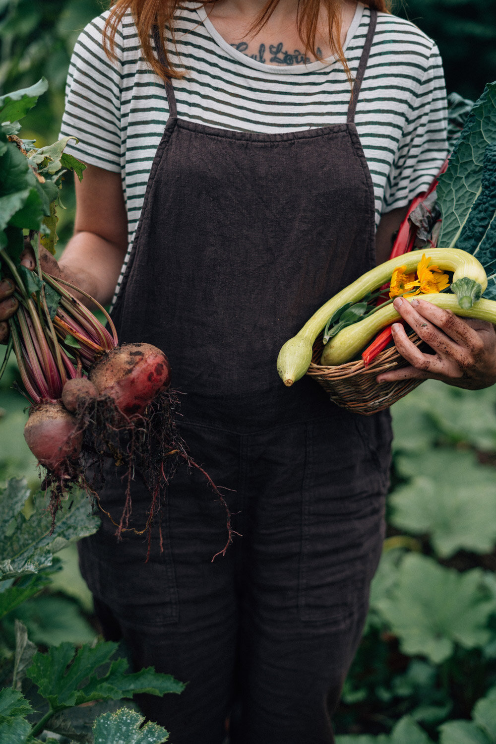 Hortelana con verduras recién cosechadas: remolachas con hojas en la mano y una cesta llena
