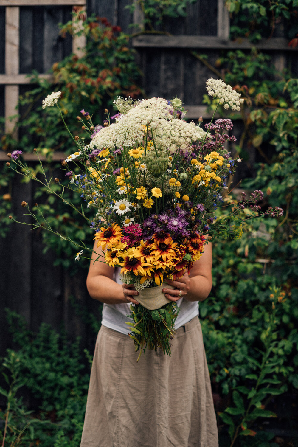 Mujer con un gran ramo de flores silvestres hecho a mano