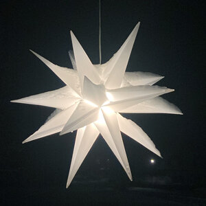 Estrella de Adviento blanca iluminada en la oscuridad