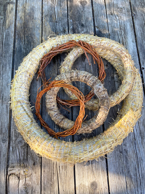 Bases para coronas de paja y ramas de sauce sobre tablas de madera